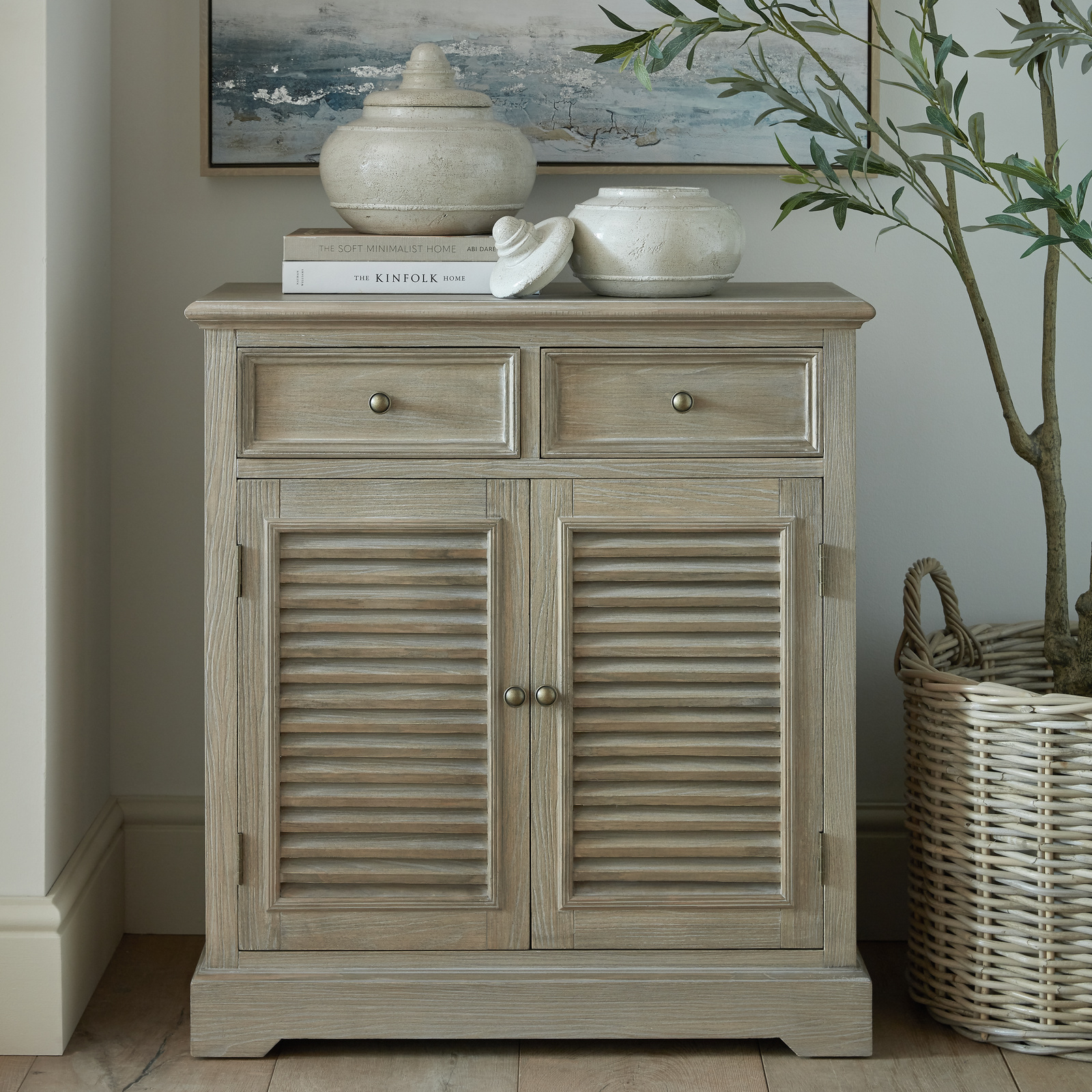 Image shows a pale wood storage cabinet with two drawers set above two doors with louvre-style finish.