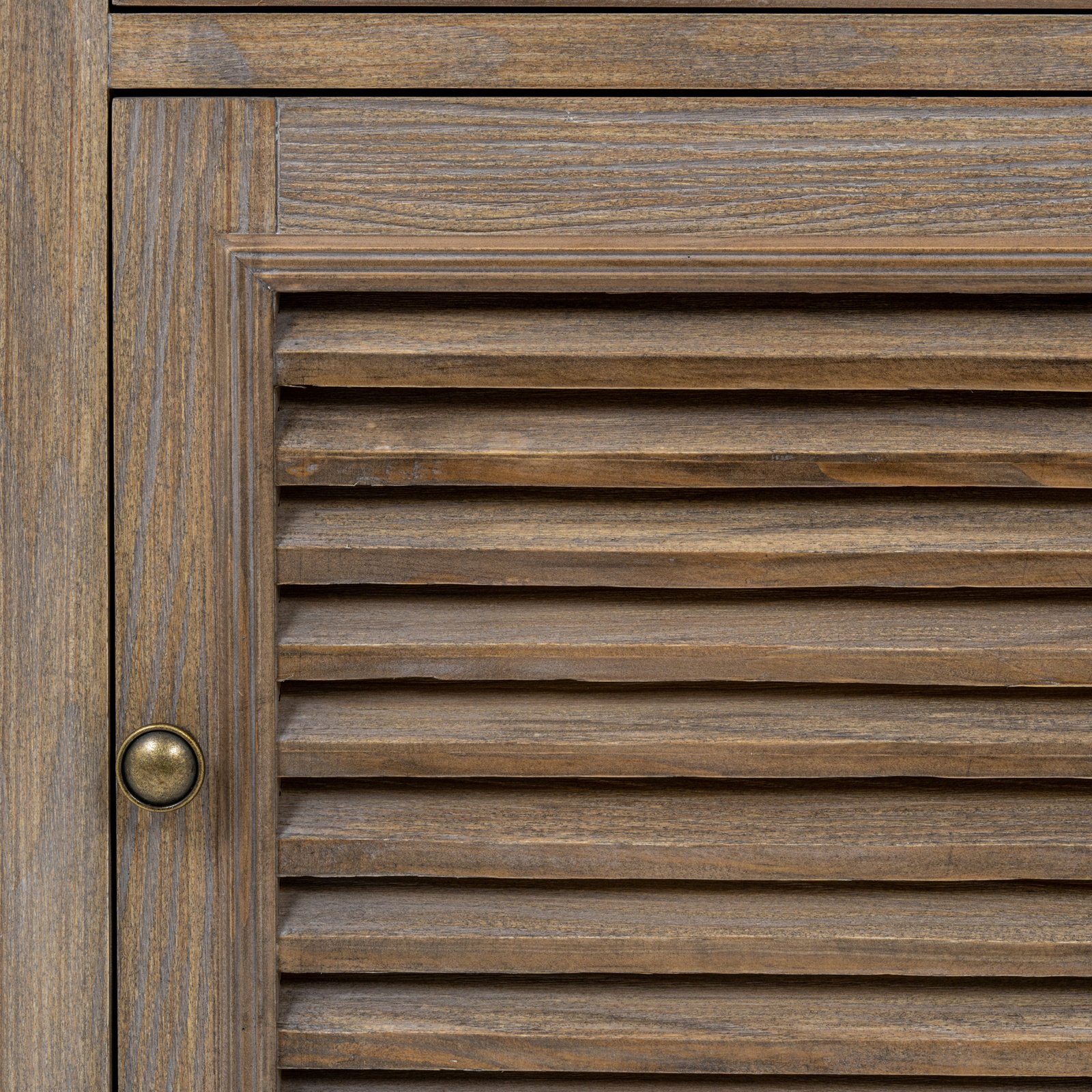 The image shows a close up of the louvred door and handle of a brown wooden cabinet.
